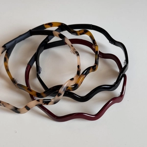 Detail of wavy acetate headbands with anti-slip teeth in four assorted colors