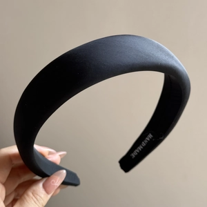 Close-up of handmade black satin padded headband with premium smooth silk texture detail