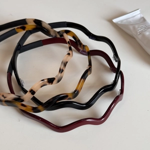 Detail view of wavy acetate headbands with non-slip teeth in tortoise and black colors