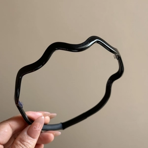 Close-up of wavy acetate headband featuring clear non-slip teeth for secure daily wear