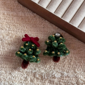 Close-up of handmade Christmas tree hair clips made of green chenille stems with pearls