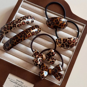 5-piece leopard print hair accessory set with bows and clips on a jewelry display tray