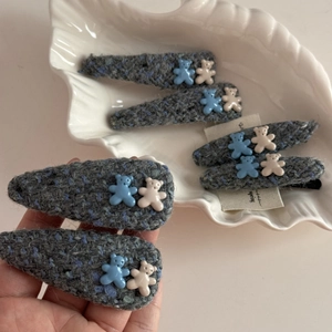 Detailed view of cute bear resin charms on a soft blue tweed fabric BB hair clip