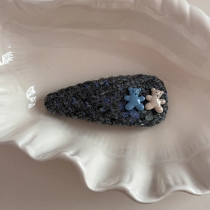Detailed macro of dark grey knitted BB hair clip with two cute resin bear charms
