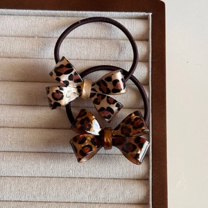 Vintage leopard print bow hair ties with high-elastic resin accents on a tray