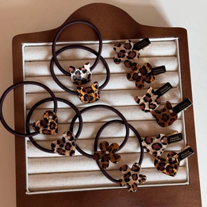 Detailed close-up of leopard print hair accessories featuring heart and flower shapes
