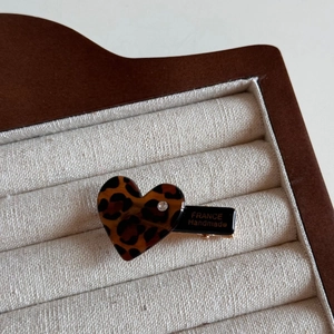 Detailed macro view of heart-shaped leopard print hair clip with France Handmade lettering
