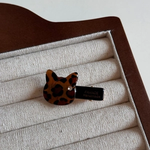 Detail of leopard print cat hair clip with sparkling crystal on a luxury display