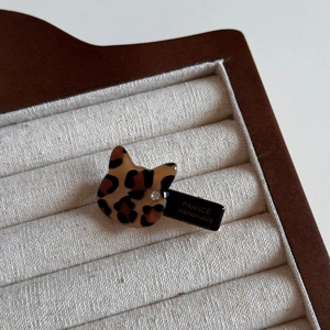 Detailed close-up of leopard cat hair clip featuring France Handmade gold lettering