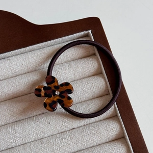 Close-up of leopard print flower hair clip with sparkling crystal center on tray