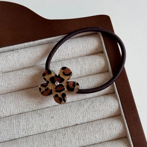 Detail of leopard print flower hair tie with a sparkling crystal center in a display box