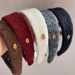 Gros plan de serre-têtes en peluche de cinq couleurs avec détail en métal doré ovale