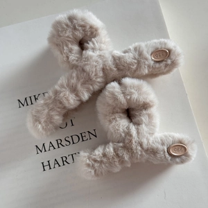 Détail de la grande pince à cheveux en peluche avec fourrure douce et logo egg élégant