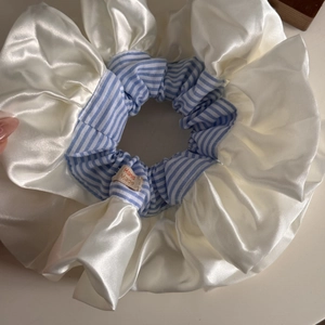 Detail of oversized cream satin scrunchie with blue stripes and Hand Made woven label