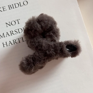 Détail de la pince à cheveux en peluche gris foncé avec texture douce et fini élégant