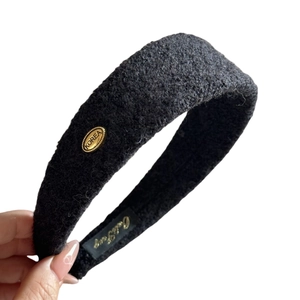 Serre-tête large en peluche noire avec étiquette dorée pour coiffure volumineuse