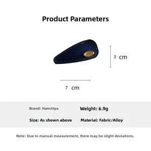 Detailed view of denim fabric hair clip with egg logo and 7cm by 3cm size measurements