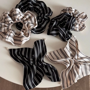 Flat lay of vintage striped hair scrunchies and matching bow ribbons with pearl texture