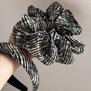 Macro detail of zebra pattern scrunchie and headband with shimmering metallic fabric