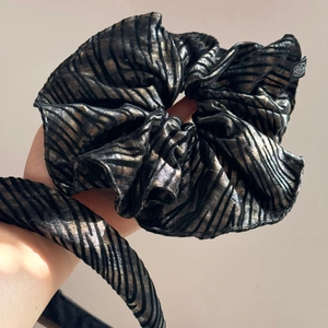 Close-up of zebra pattern scrunchie with shiny metallic texture and rose brand tag