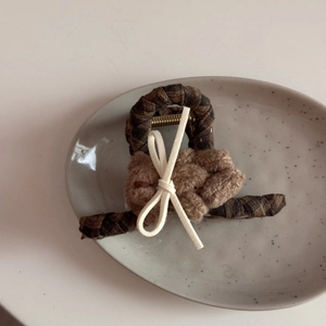 Detailed shot of vintage brown plaid fabric hair claw clip with plush bear and white bow