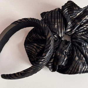 Close-up of zebra pattern scrunchie and headband with metallic bronze fabric texture