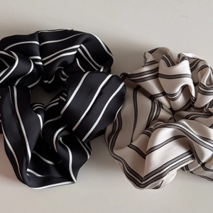 Detailed view of striped satin scrunchies with elegant pearl luster and vintage texture
