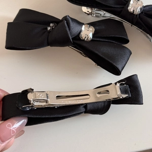 Détail du nœud papillon en satin noir avec cristaux et mécanisme de clip Paris