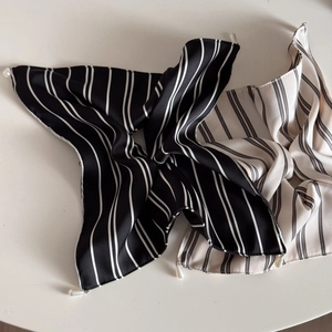 Detailed view of striped silk scrunchies featuring elegant hanging pearl pendants