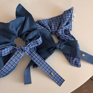 Detailed shot of blue denim and checkered bow scrunchies with gold charm accents