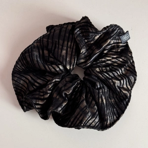 Detail shot of zebra pattern scrunchie with metallic gold and black textured fabric