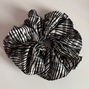 Detailed view of large zebra stripe satin scrunchie with silky texture and black number 5 tag
