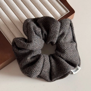 Macro shot of dark taupe herringbone wool scrunchie with detailed fabric texture
