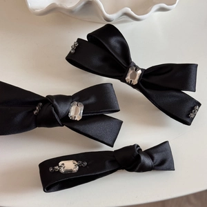 Gros plan de barrettes nœuds en satin noir avec accents élégants en cristal étincelant