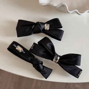 Vue détaillée de barrettes nœuds en satin noir avec ornements en cristal brillant