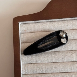 Detailed macro shot of vintage black velvet BB hair clip with square crystal and silver pendant