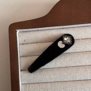 Detail of velvet hair clip featuring a square rhinestone and embossed silver horse coin