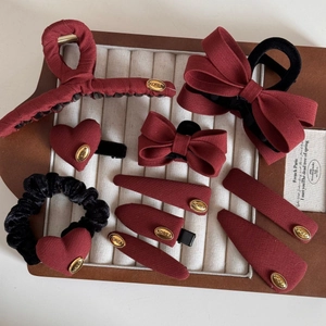 Detail of red fabric bow hair clips and gold label accessories set for women