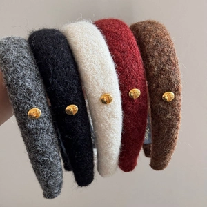 Close-up of colorful wool headbands with gold engraved buckles showing plush texture