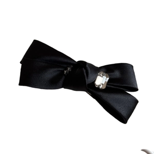Barrette à cheveux élégante en satin noir avec centre en cristal sur fond blanc