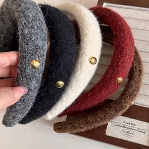 Close-up of wool texture headbands with gold oval buckles in various autumn colors