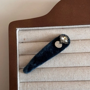 Macro shot of blue velvet BB clip with square rhinestone and silver handmade tag