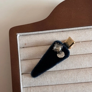 Detail of vintage velvet hair clip with square crystal and silver pendant in a jewelry box