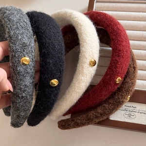 Detailed close-up of wool headband collection with elegant gold button accents