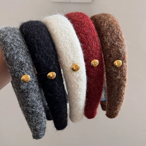 Detailed view of plush wool headbands in five autumn colors with golden metal buckles