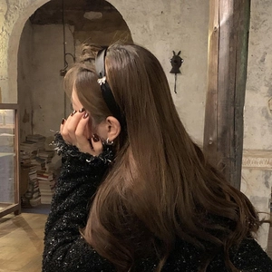 Serre-tête élégant en satin noir avec un nœud orné de strass porté par un modèle