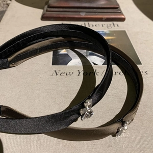 Vue détaillée de serre-têtes en satin avec nœuds en strass en noir et vert olive foncé