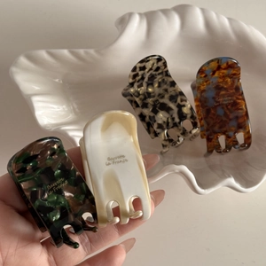 Detail showing four assorted acetate hair claws with marble and tortoiseshell patterns
