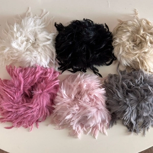 Detailansicht flauschiger Haargummis aus Kunstfedern in sechs eleganten Farben für den Winter
