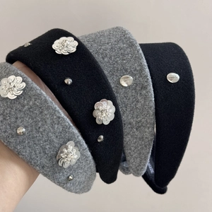 Detail of wide sequin flower headbands in black and grey with metallic rivets